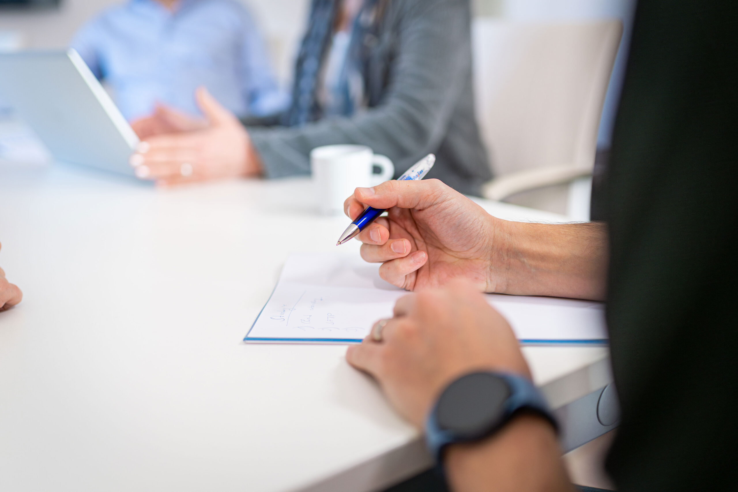 Mitarbeitende besprechen Dokumente und Daten im Rahmen regulatorischer Reporting-Prozesse.