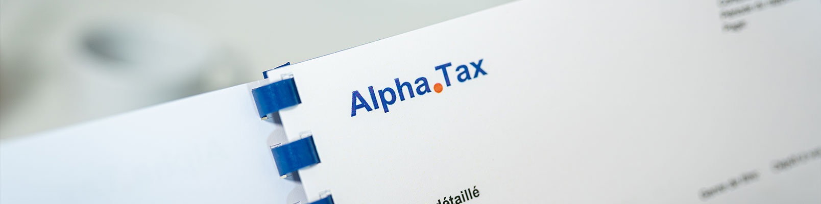 Dokument mit AlphaTax-Logo in einer Büroumgebung.